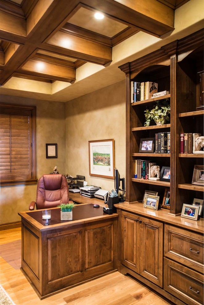 This is an example of a mid-sized country study room in Other with beige walls, light hardwood floors and a built-in desk.