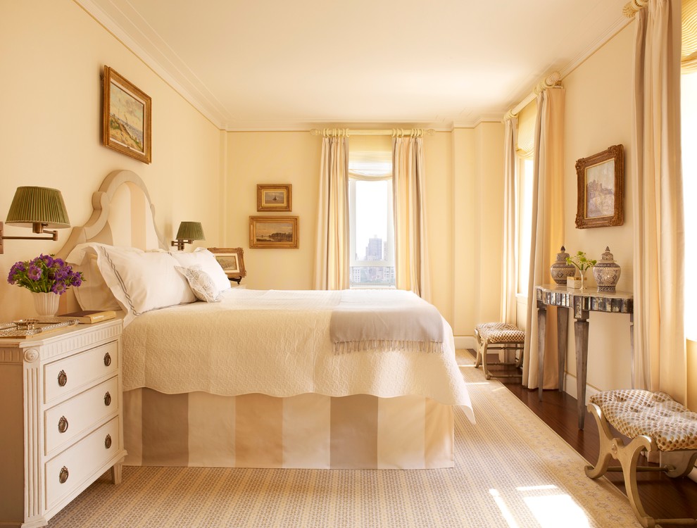 This is an example of a mid-sized traditional master bedroom in New York with yellow walls and dark hardwood floors.