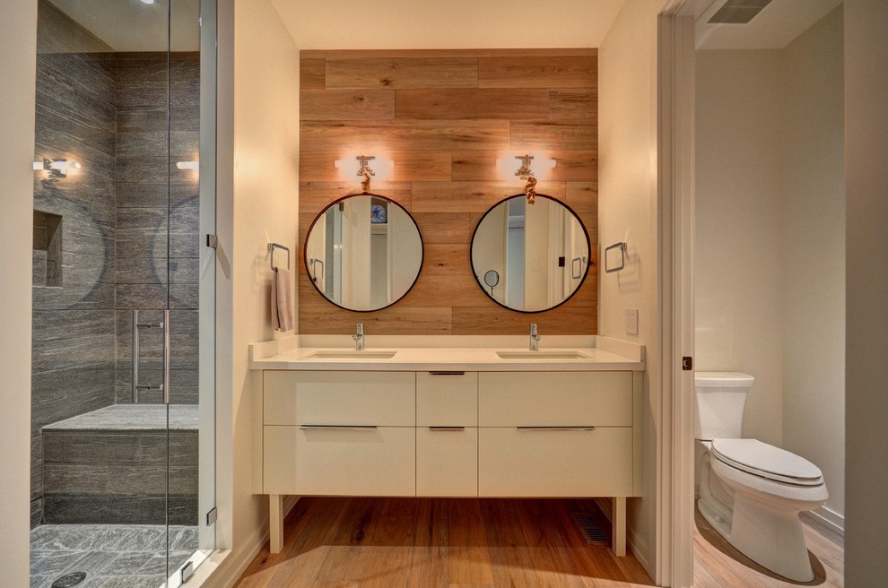Mid-sized contemporary 3/4 bathroom in Toronto with flat-panel cabinets, yellow cabinets, an alcove shower, a one-piece toilet, gray tile, stone tile, white walls, light hardwood floors, an undermount sink and engineered quartz benchtops.