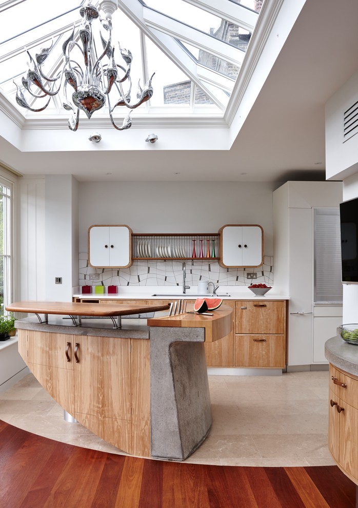 Photo of an eclectic kitchen in London with an undermount sink, flat-panel cabinets, light wood cabinets, multi-coloured splashback, medium hardwood floors and with island.