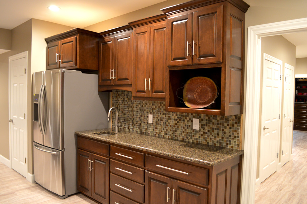 Eat-in kitchen - mid-sized transitional single-wall porcelain tile and beige floor eat-in kitchen idea with raised-panel cabinets, medium tone wood cabinets, solid surface countertops, multicolored backsplash, glass tile backsplash, an undermount sink, stainless steel appliances and an island