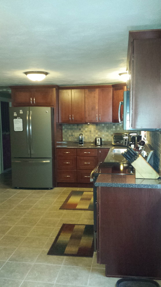 Example of a mid-sized transitional l-shaped eat-in kitchen design in Miami with a drop-in sink, recessed-panel cabinets, medium tone wood cabinets, granite countertops, beige backsplash, subway tile backsplash, stainless steel appliances and no island
