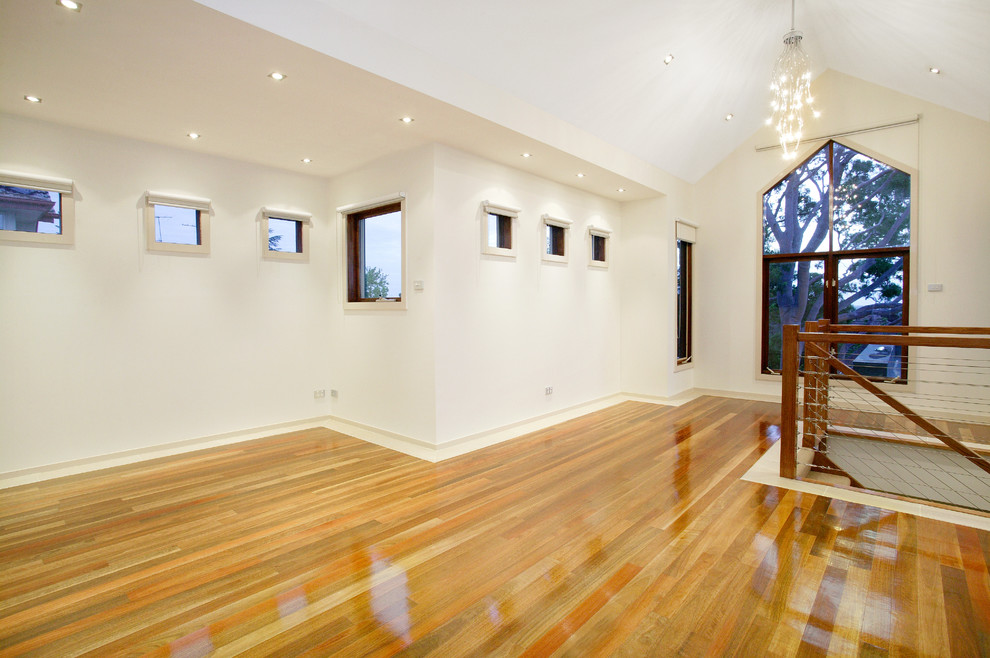 Inspiration for a contemporary open concept living room in Melbourne with beige walls and medium hardwood floors.