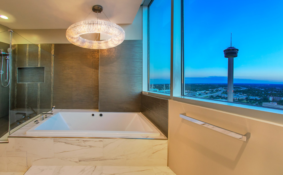 Mid-sized contemporary master bathroom in Austin with flat-panel cabinets, medium wood cabinets, a drop-in tub, a corner shower, a bidet, white tile, marble, grey walls, porcelain floors, an undermount sink, engineered quartz benchtops, white floor and a hinged shower door.