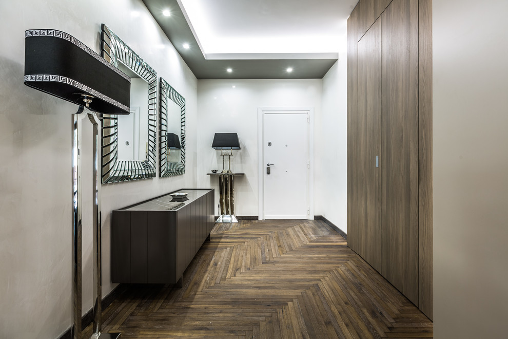 Design ideas for a contemporary entry hall in Rome with white walls, dark hardwood floors, a white front door, a single front door and brown floor.