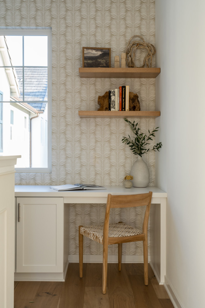 Foto på ett litet skandinaviskt arbetsrum, med beige väggar, ljust trägolv, ett inbyggt skrivbord och beiget golv