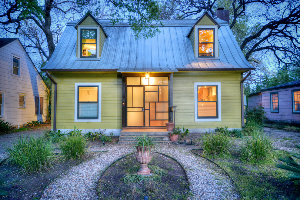 Design ideas for an eclectic two-storey green exterior in Austin with wood siding.