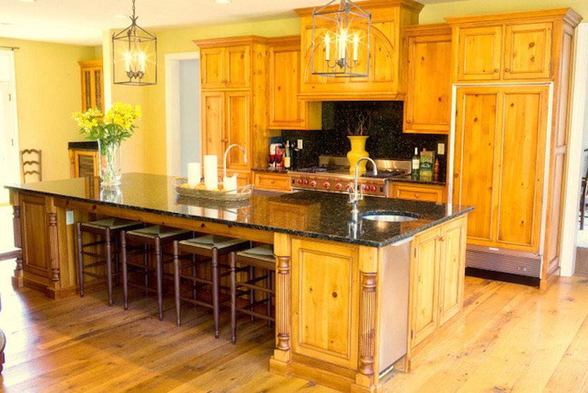 Example of a large mountain style single-wall light wood floor eat-in kitchen design in Philadelphia with an undermount sink, recessed-panel cabinets, light wood cabinets, granite countertops, stone slab backsplash, paneled appliances and an island