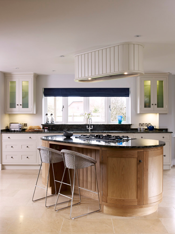 Large contemporary open plan kitchen in London with an integrated sink, shaker cabinets, white cabinets, granite benchtops, stainless steel appliances and with island.
