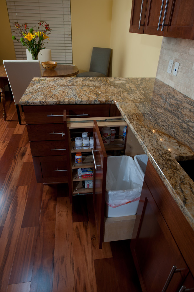 Inspiration for a transitional galley medium tone wood floor eat-in kitchen remodel in Austin with an undermount sink, recessed-panel cabinets, medium tone wood cabinets, granite countertops, beige backsplash, ceramic backsplash, yellow walls and no island