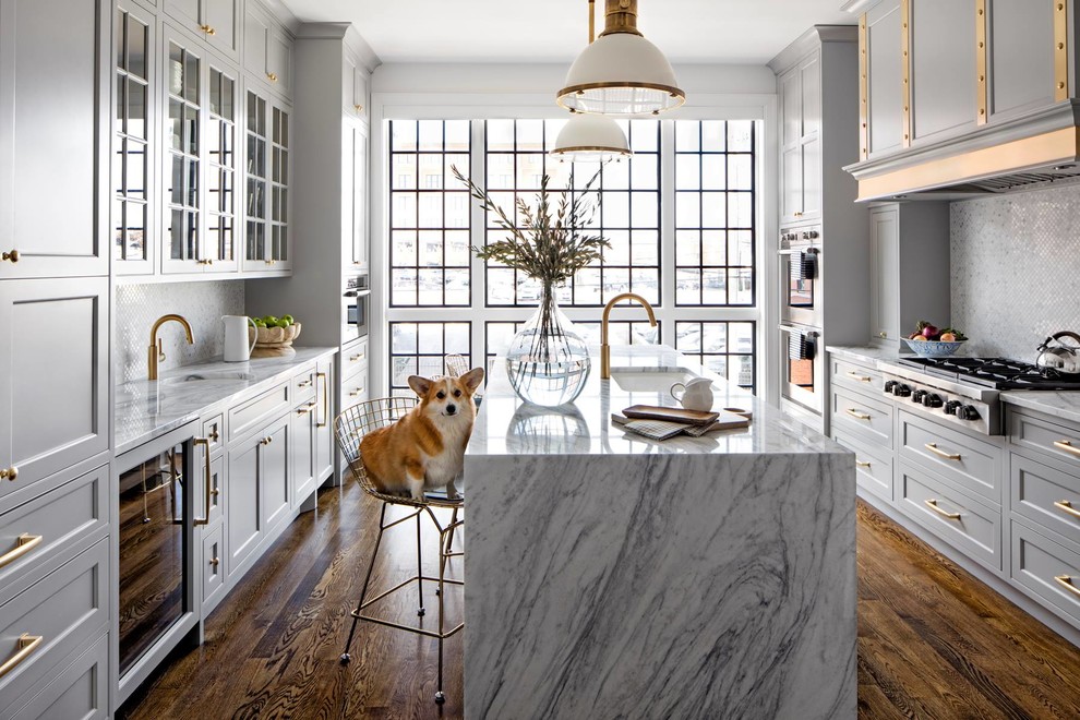 Kitchen - transitional galley medium tone wood floor and brown floor kitchen idea in Minneapolis with an undermount sink, shaker cabinets, gray cabinets, gray backsplash, mosaic tile backsplash, an island and white countertops