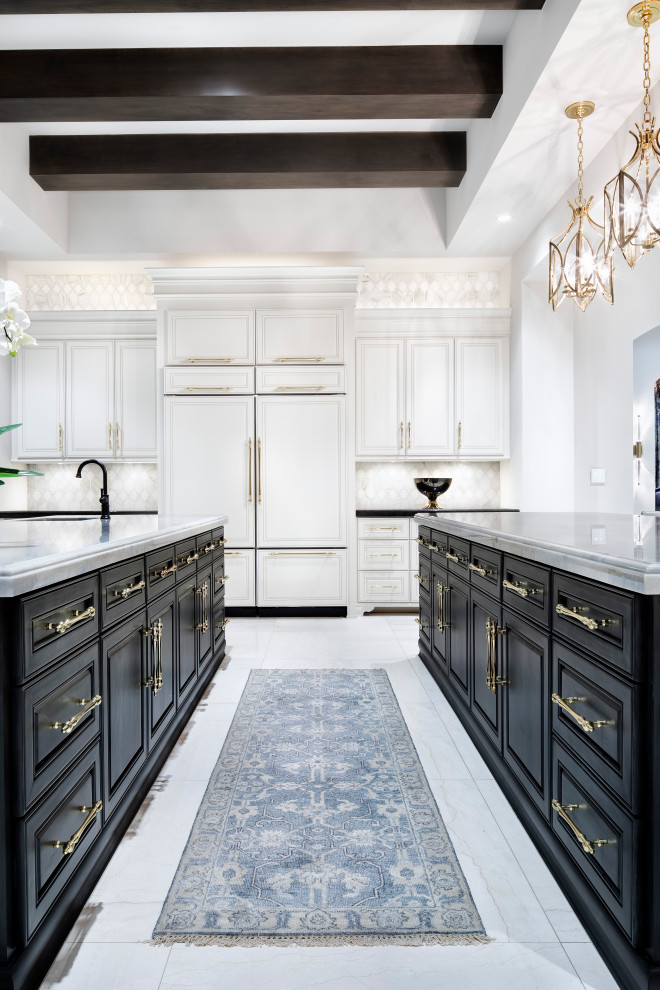 Expansive transitional u-shaped open plan kitchen in Austin with an undermount sink, raised-panel cabinets, black cabinets, quartz benchtops, grey splashback, mosaic tile splashback, panelled appliances, marble floors, multiple islands, white floor, white benchtop and exposed beam.