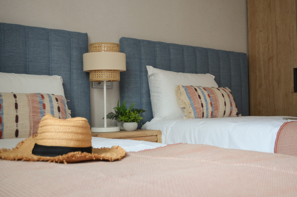 Mid-sized mediterranean guest bedroom in Malaga with beige walls, porcelain floors, grey floor and wallpaper.