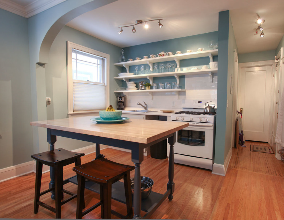 Small transitional single-wall light wood floor eat-in kitchen photo in Minneapolis with a single-bowl sink, shaker cabinets, white cabinets, laminate countertops, white backsplash, subway tile backsplash, white appliances and an island