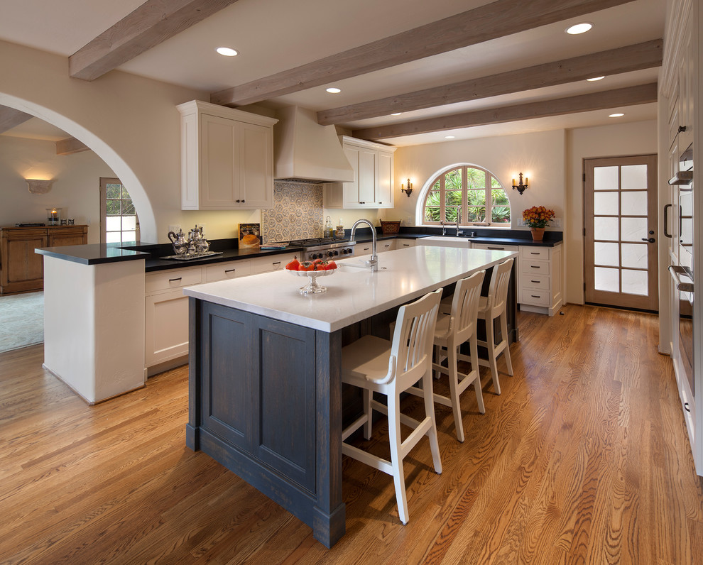 Inspiration for a mediterranean l-shaped eat-in kitchen in Santa Barbara with a farmhouse sink, medium hardwood floors and with island.