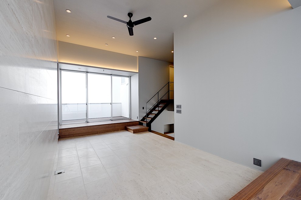 This is an example of a modern loft-style living room in Tokyo Suburbs with white walls, limestone floors, no fireplace and white floor.