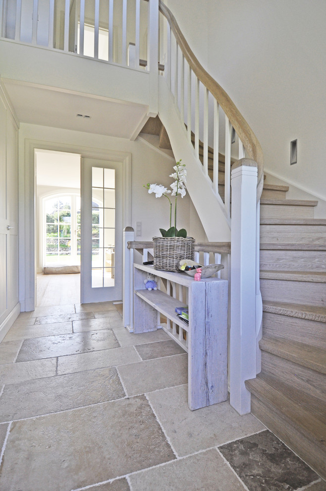 This is an example of a mid-sized beach style wood curved staircase in Other with wood risers.