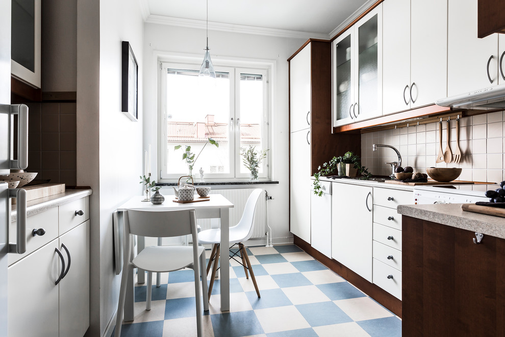 Mid-sized scandinavian l-shaped eat-in kitchen in Stockholm with flat-panel cabinets, white cabinets, beige splashback, no island and blue floor.