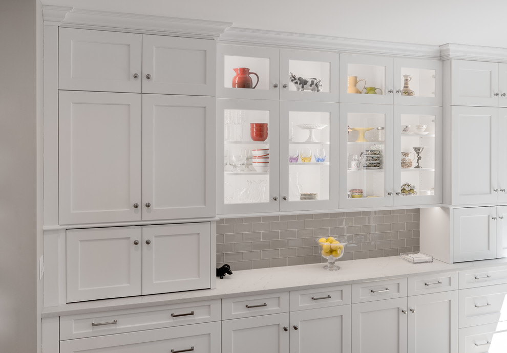 Inspiration for a transitional u-shaped eat-in kitchen remodel in Providence with an undermount sink, white cabinets, quartzite countertops, glass tile backsplash, stainless steel appliances and an island
