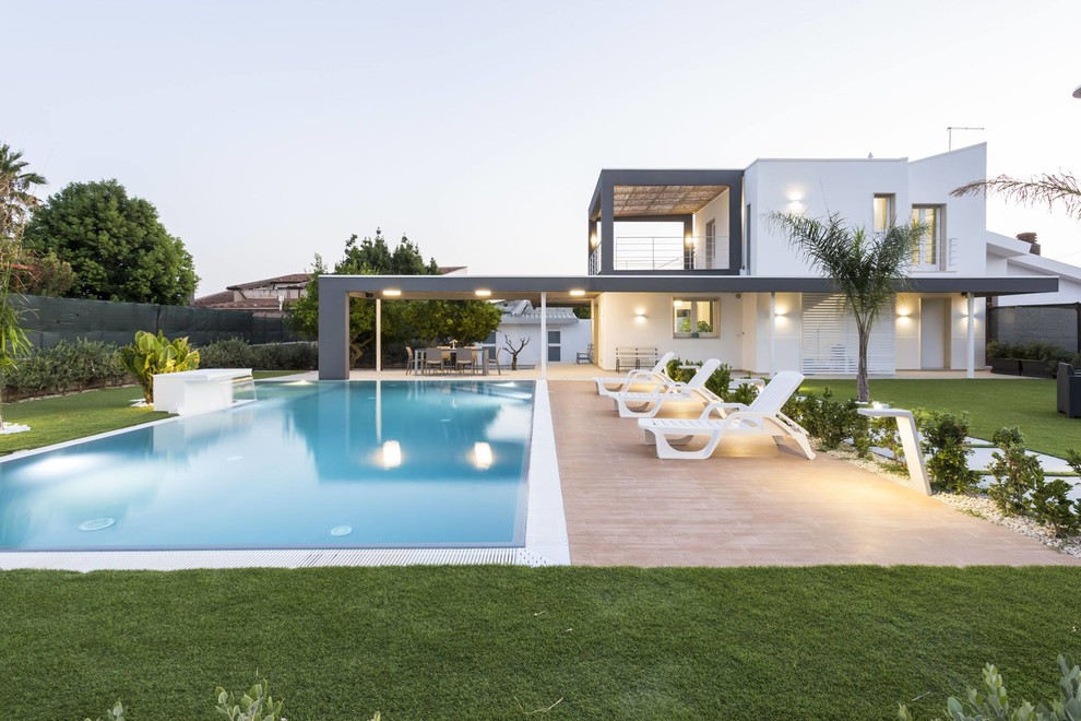 Inspiration for a contemporary backyard rectangular pool in Rome with a water feature.