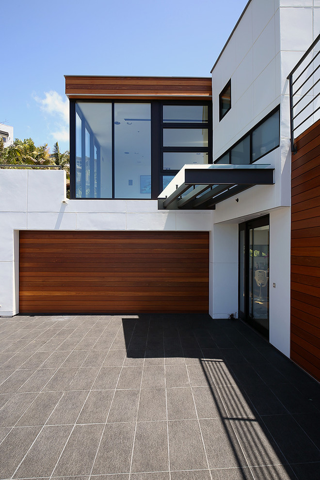 Photo of a mid-sized contemporary three-storey white house exterior in Orange County with wood siding and a flat roof.