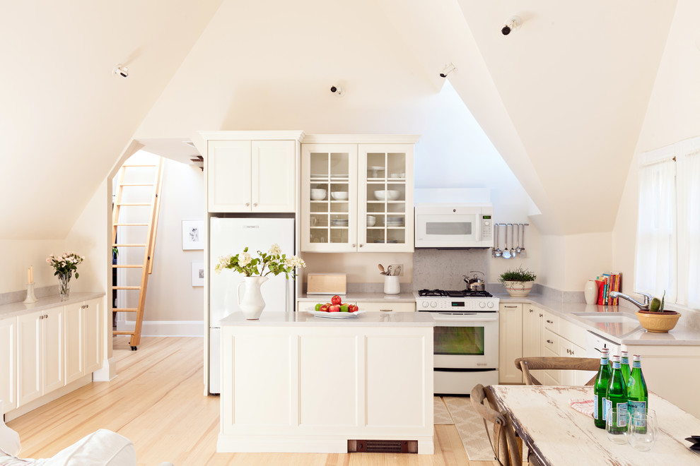 Eat-in kitchen - mid-sized transitional l-shaped medium tone wood floor eat-in kitchen idea in Boston with white cabinets, an island, an undermount sink, shaker cabinets, quartz countertops, white appliances, gray backsplash and stone slab backsplash