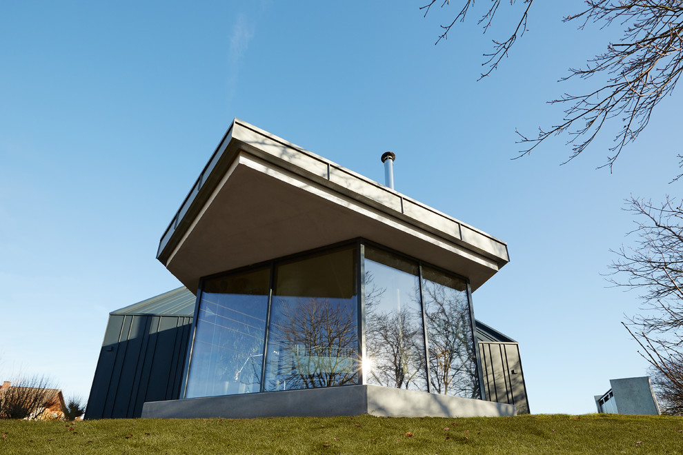 Moderner Wintergarten mit Betonboden und Kaminofen in Nürnberg