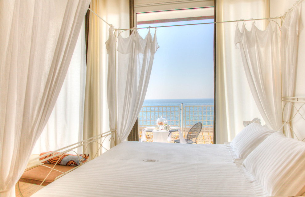 Design ideas for a beach style master bedroom in Venice with white walls.