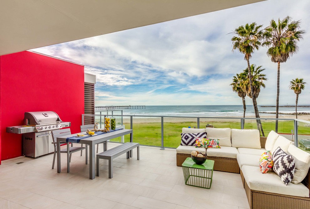 This is an example of a mid-sized beach style backyard patio in San Diego with no cover and tile.