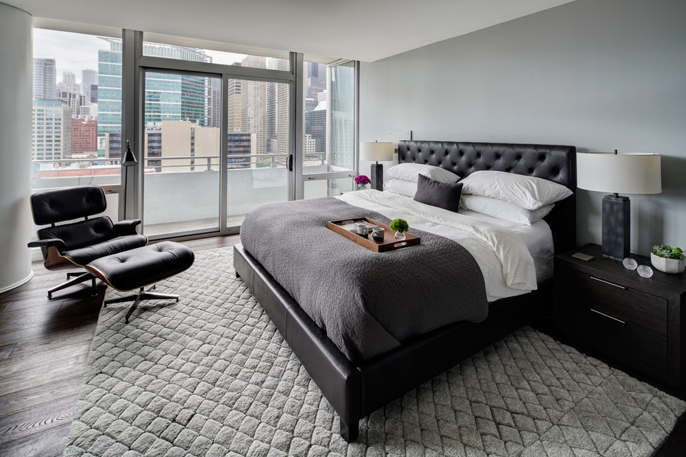 This is an example of a large contemporary master bedroom in Chicago with grey walls, dark hardwood floors and brown floor.