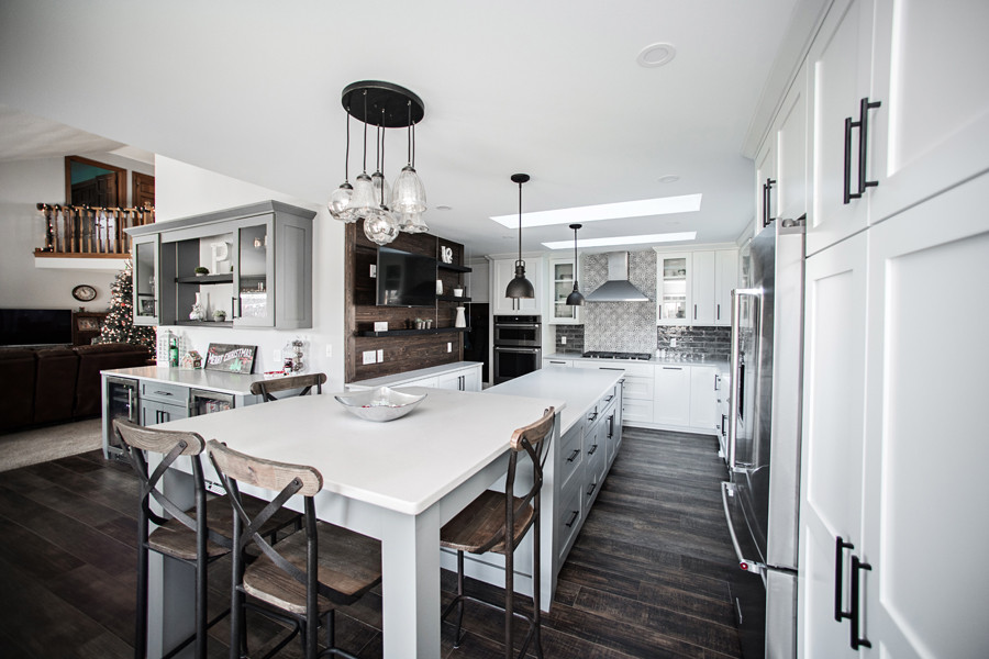 Inspiration for a large country l-shaped open plan kitchen in Milwaukee with shaker cabinets, white cabinets, quartz benchtops, grey splashback, glass tile splashback, with island and white benchtop.