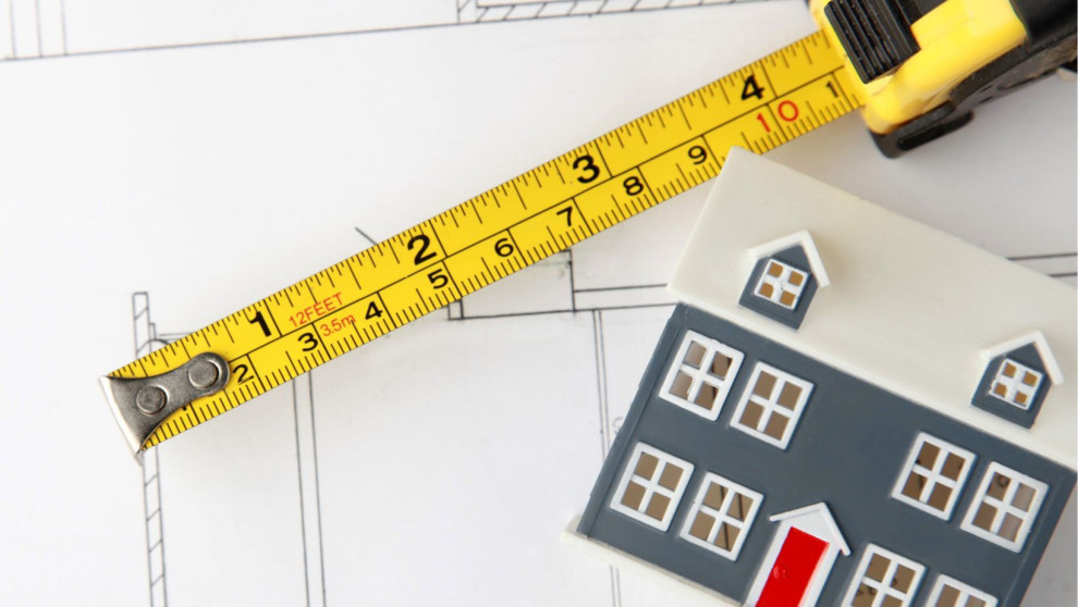measuring tape, house model on floor plan