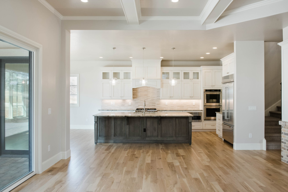 Inspiration for a large transitional l-shaped light wood floor and brown floor eat-in kitchen remodel in Denver with an undermount sink, flat-panel cabinets, gray cabinets, granite countertops, beige backsplash, stainless steel appliances, an island and gray countertops