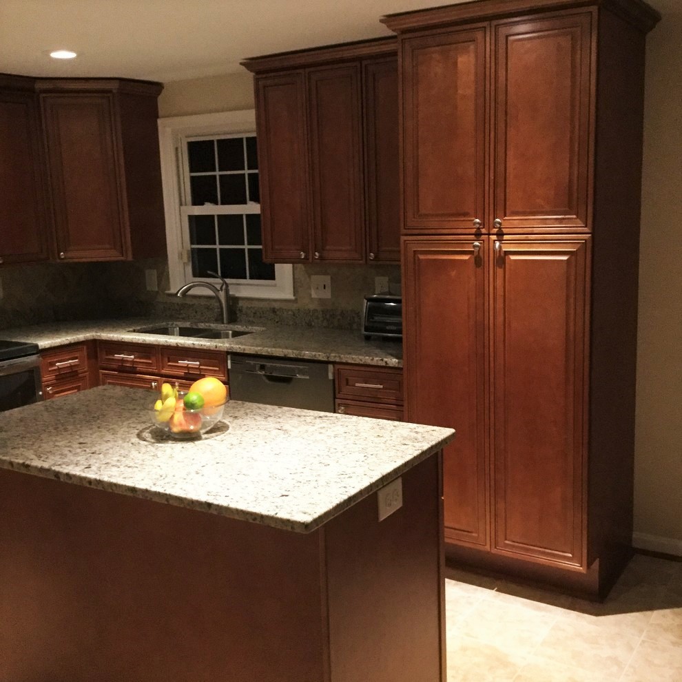 Large transitional l-shaped porcelain tile eat-in kitchen photo in DC Metro with an undermount sink, raised-panel cabinets, medium tone wood cabinets, granite countertops, beige backsplash, porcelain backsplash, stainless steel appliances and an island