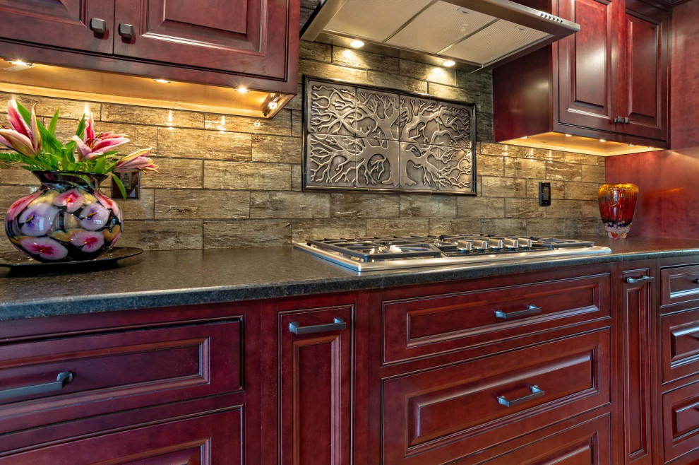 Eat-in kitchen - large transitional single-wall light wood floor and brown floor eat-in kitchen idea in Philadelphia with an undermount sink, raised-panel cabinets, red cabinets, granite countertops, brown backsplash, porcelain backsplash, stainless steel appliances, an island and brown countertops