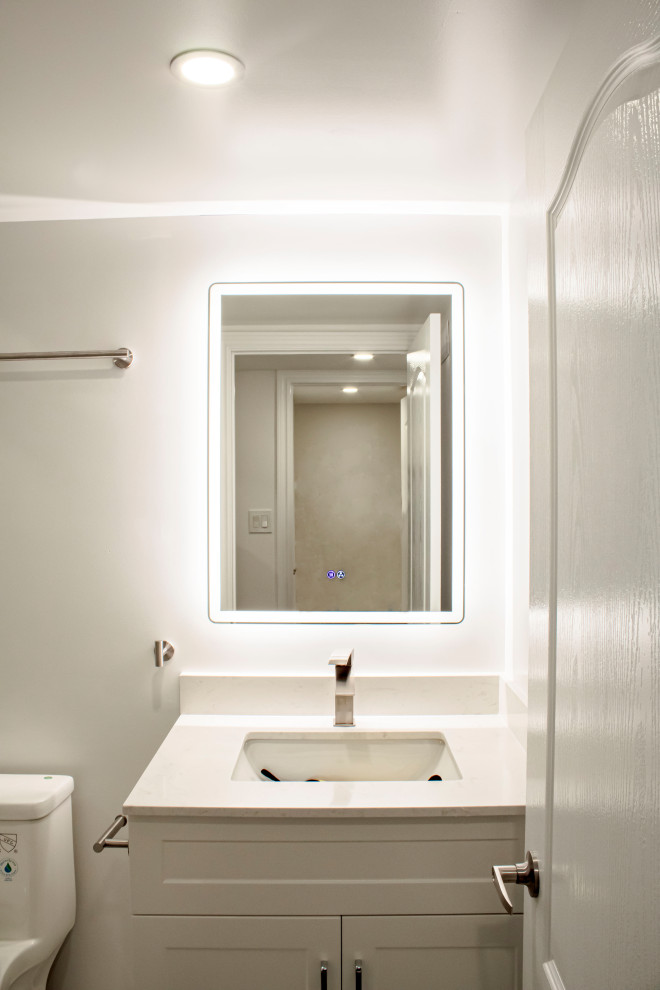Exempel på ett vit vitt badrum, med skåp i shakerstil, vita skåp, vit kakel, kakel i småsten, vita väggar, klinkergolv i porslin, bänkskiva i kvarts, vitt golv och dusch med skjutdörr
