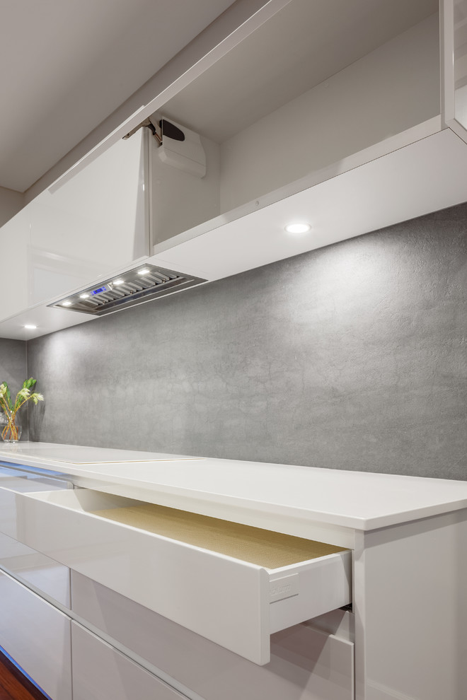 Photo of a large modern single-wall separate kitchen in Perth with a drop-in sink, louvered cabinets, white cabinets, granite benchtops, beige splashback, cement tile splashback, black appliances, terra-cotta floors and with island.