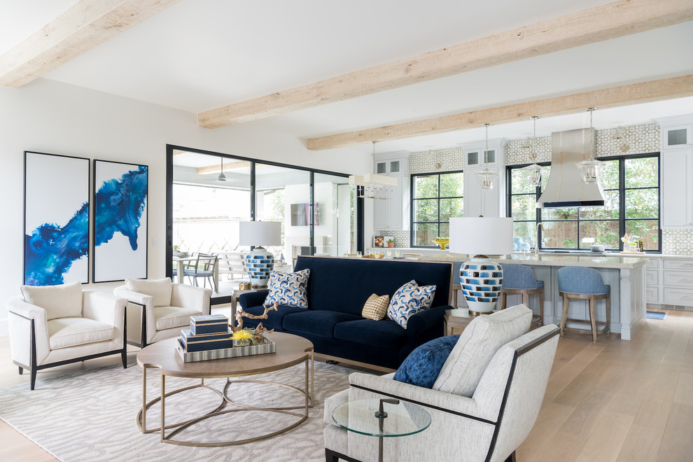 This is an example of a large transitional open concept family room in Dallas with white walls, light hardwood floors, a wall-mounted tv and exposed beam.