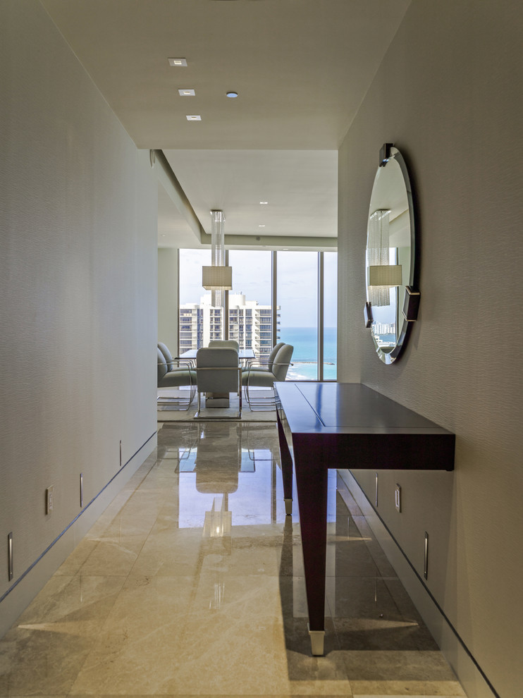 Design ideas for a mid-sized contemporary foyer in Miami with beige walls and limestone floors.