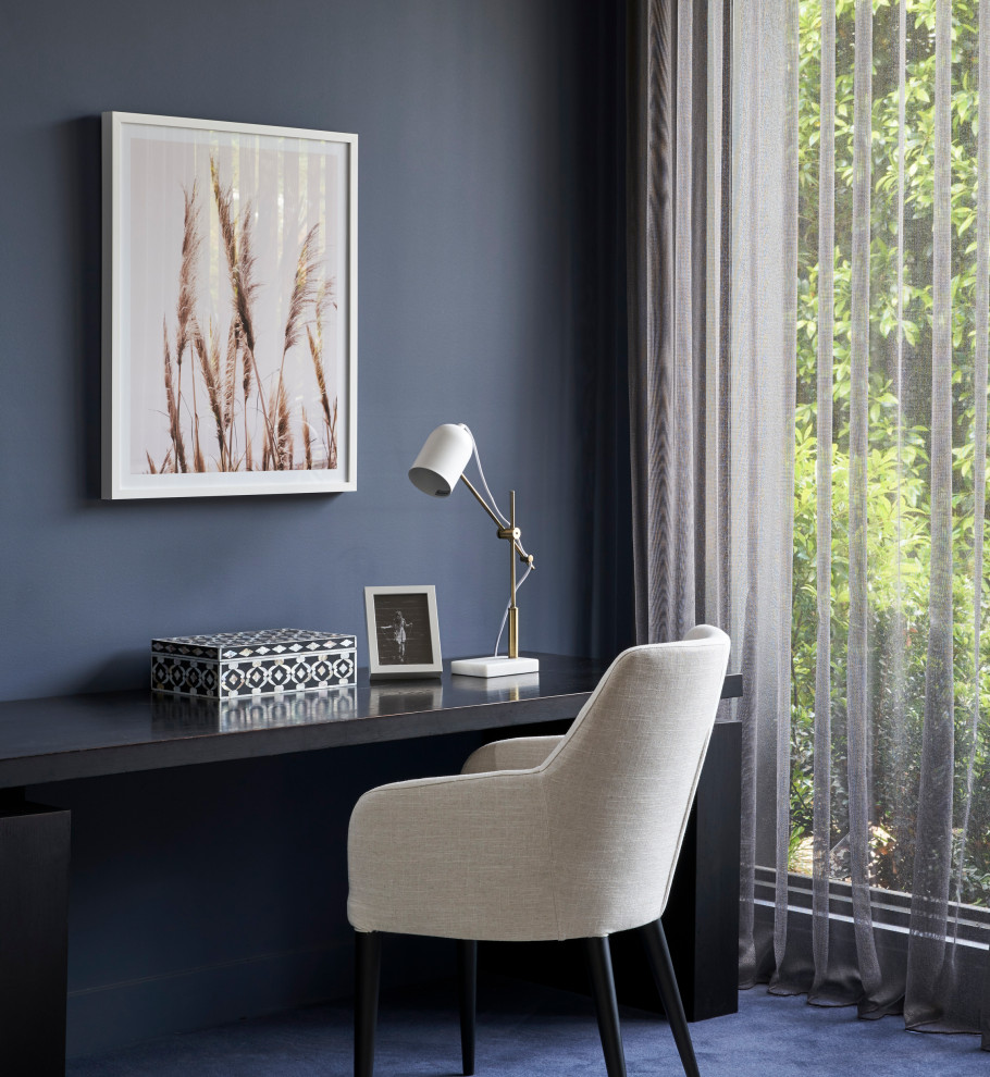 Großes Modernes Arbeitszimmer ohne Kamin mit Arbeitsplatz, blauer Wandfarbe, Teppichboden, freistehendem Schreibtisch und blauem Boden in Melbourne