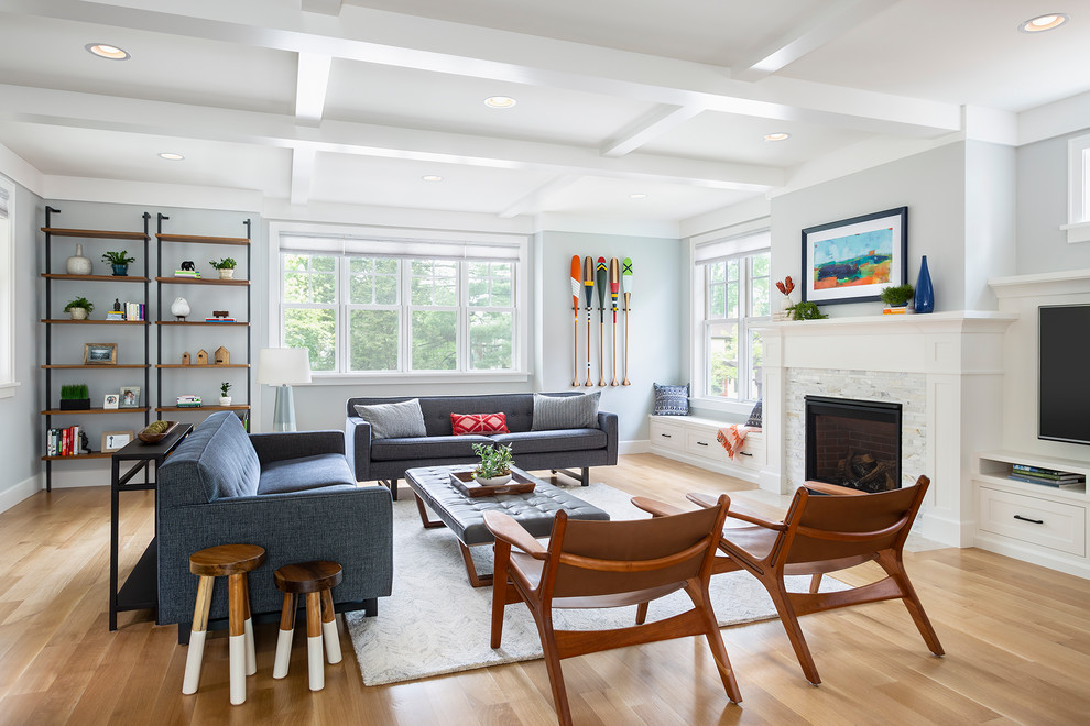 Photo of a large transitional open concept family room in Minneapolis with grey walls, a standard fireplace, a tile fireplace surround, a built-in media wall, light hardwood floors and beige floor.