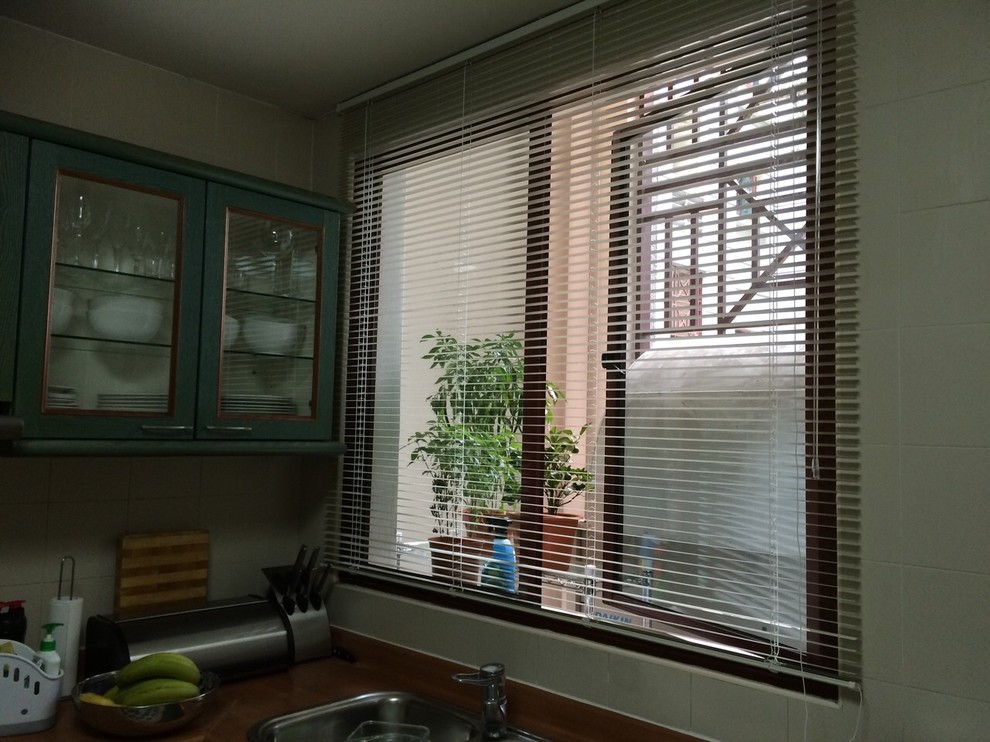 This is an example of an industrial kitchen in Singapore with glass-front cabinets and green cabinets.