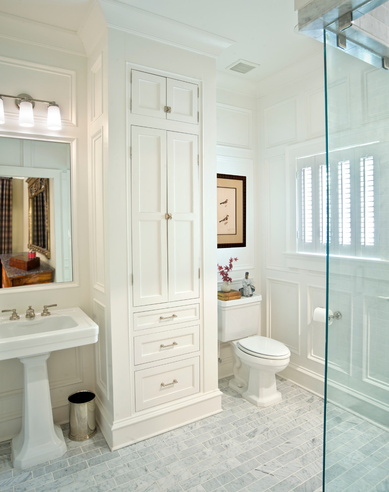 Photo of a traditional bathroom in Atlanta with a pedestal sink, shaker cabinets, white cabinets, a corner shower, a two-piece toilet and white walls.