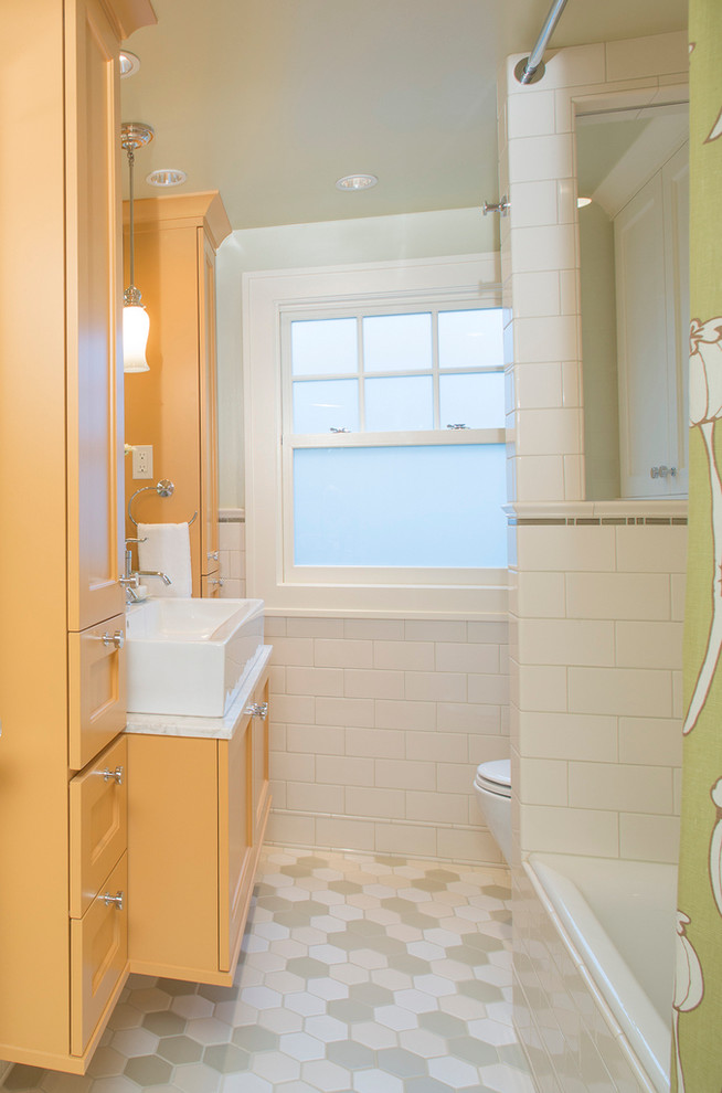 Inspiration for a small transitional bathroom in Portland with a vessel sink, shaker cabinets, marble benchtops, an alcove tub, an alcove shower, a two-piece toilet, multi-coloured tile, green walls and yellow cabinets.