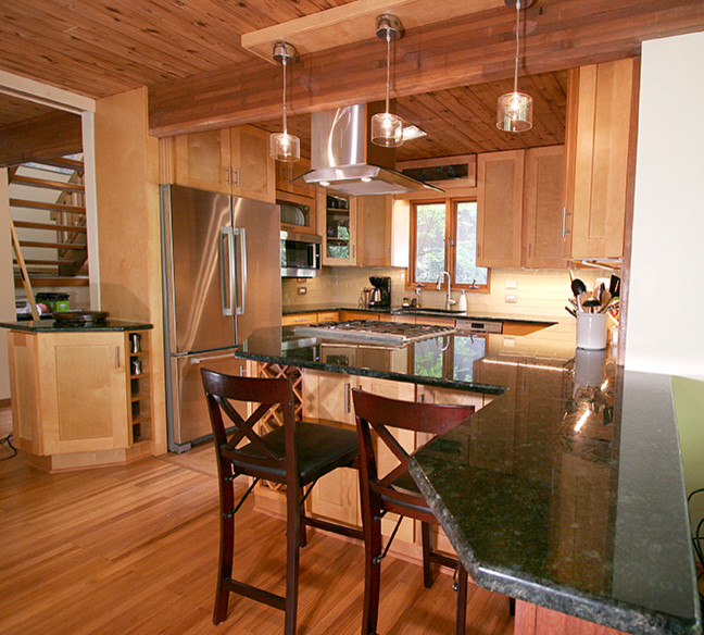 Inspiration for a small transitional l-shaped porcelain tile eat-in kitchen remodel with shaker cabinets, light wood cabinets, granite countertops, beige backsplash, glass tile backsplash, stainless steel appliances and a peninsula