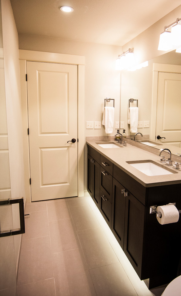 Walk-in shower - transitional gray tile and porcelain tile walk-in shower idea in Seattle with an undermount sink, shaker cabinets, black cabinets, quartzite countertops and a two-piece toilet