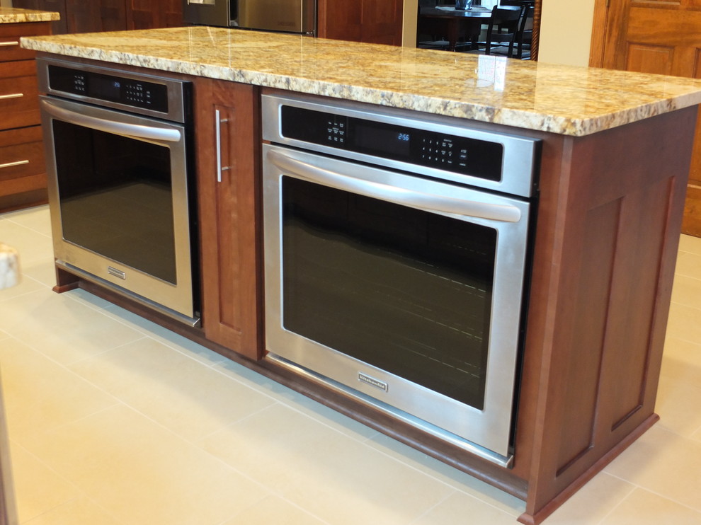 Eat-in kitchen - mid-sized transitional l-shaped ceramic tile eat-in kitchen idea in Columbus with an undermount sink, shaker cabinets, brown cabinets, granite countertops, beige backsplash, ceramic backsplash, stainless steel appliances and an island