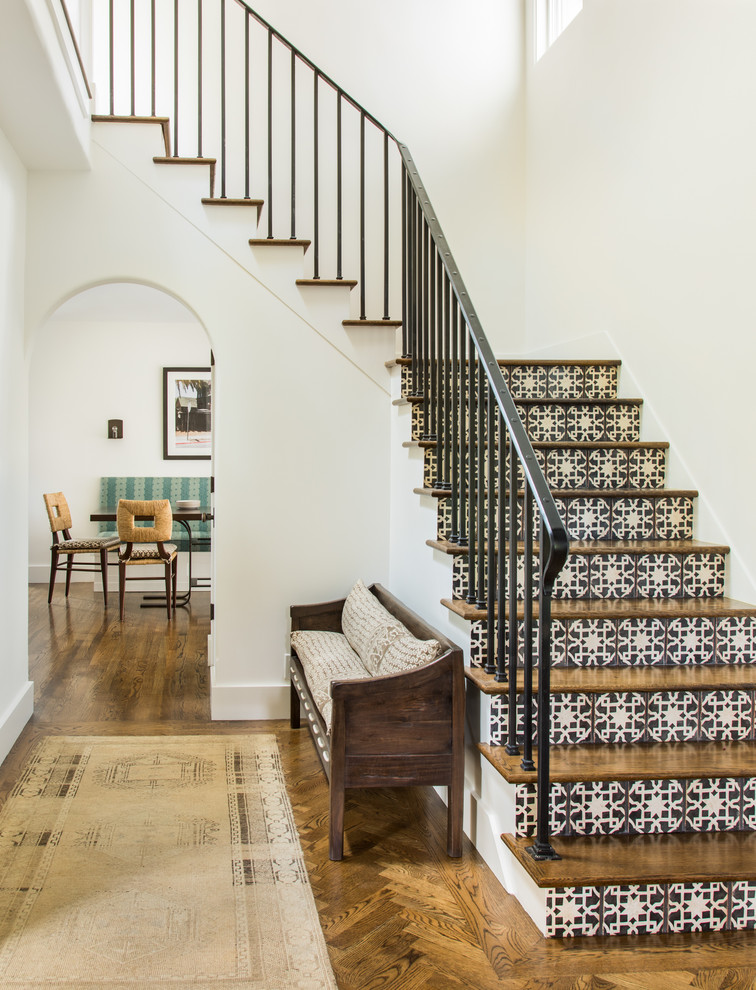 Mediterranean wood l-shaped staircase in San Francisco with tile risers and metal railing.