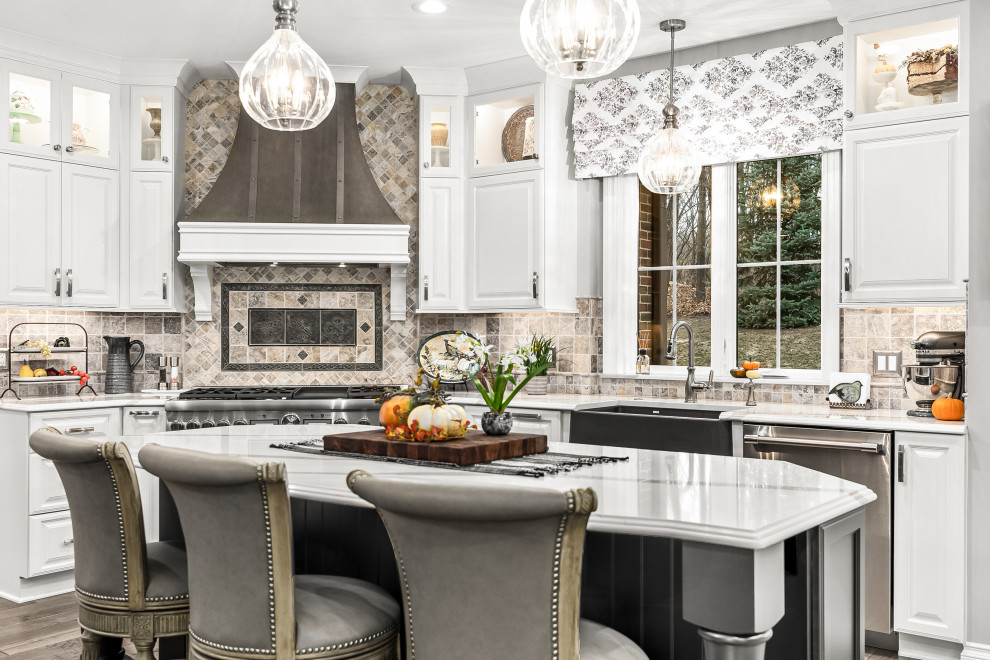 Expansive classic l-shaped kitchen/diner in Detroit with raised-panel cabinets, white cabinets, engineered stone countertops, multiple islands and white worktops.