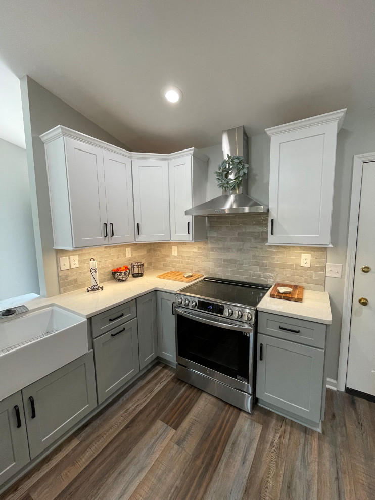 Inspiration for a mid-sized transitional u-shaped vinyl floor and brown floor eat-in kitchen remodel with a farmhouse sink, shaker cabinets, white cabinets, quartz countertops, gray backsplash, subway tile backsplash, stainless steel appliances, no island and white countertops